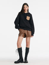 A lady wears an oversized hoodie.